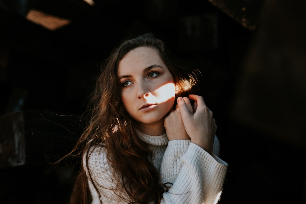 woman posing behind dark area during daytime