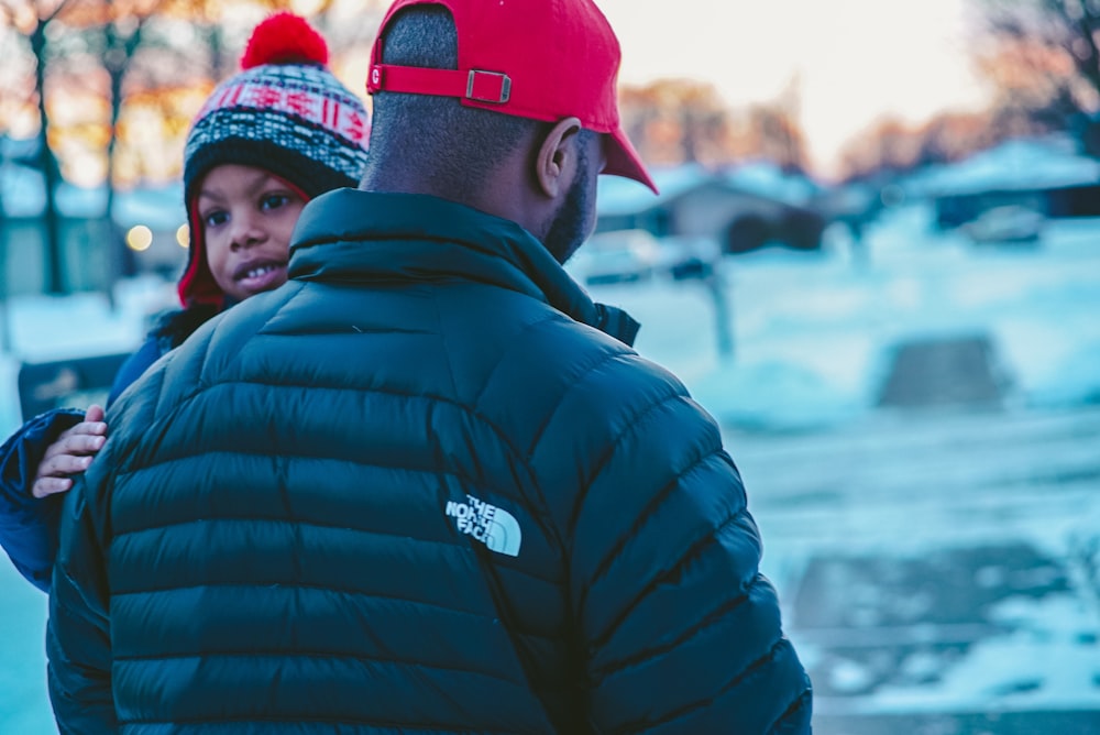 man carrying boy wearing jacket