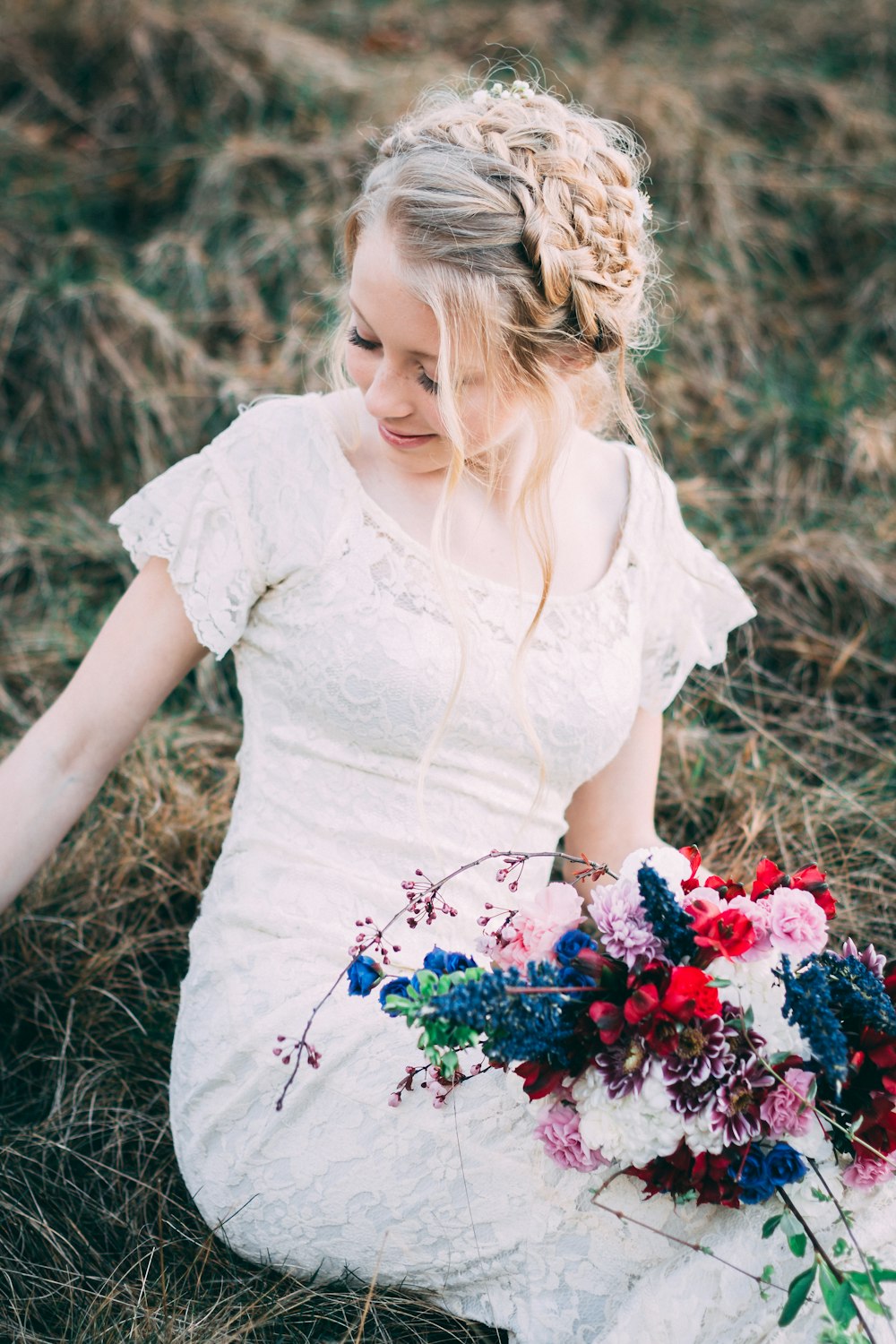 woman holding bouquet of flowers siting on hay