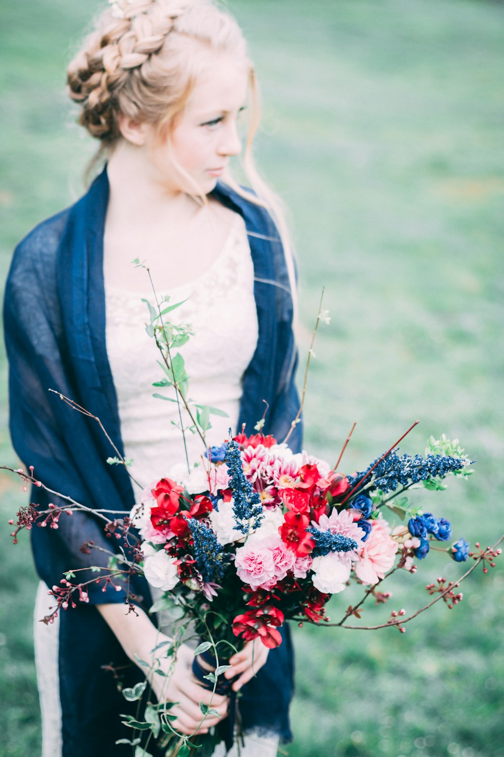 women wearing blue cardigan holding flowers