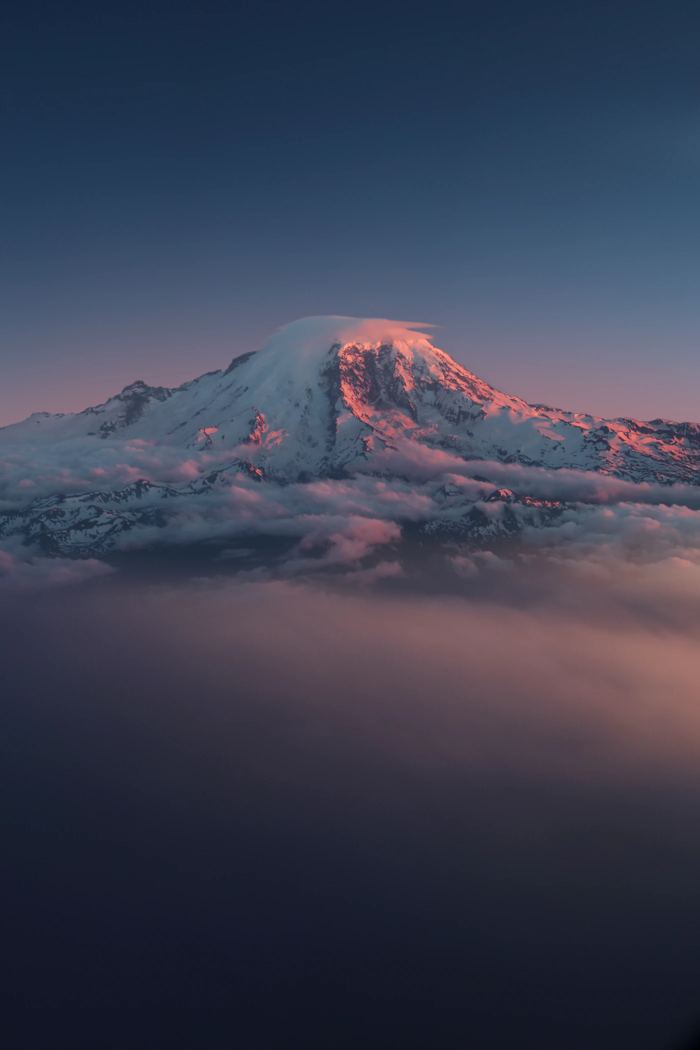 Snow-covered Mt Rainier under broken clouds, Washington