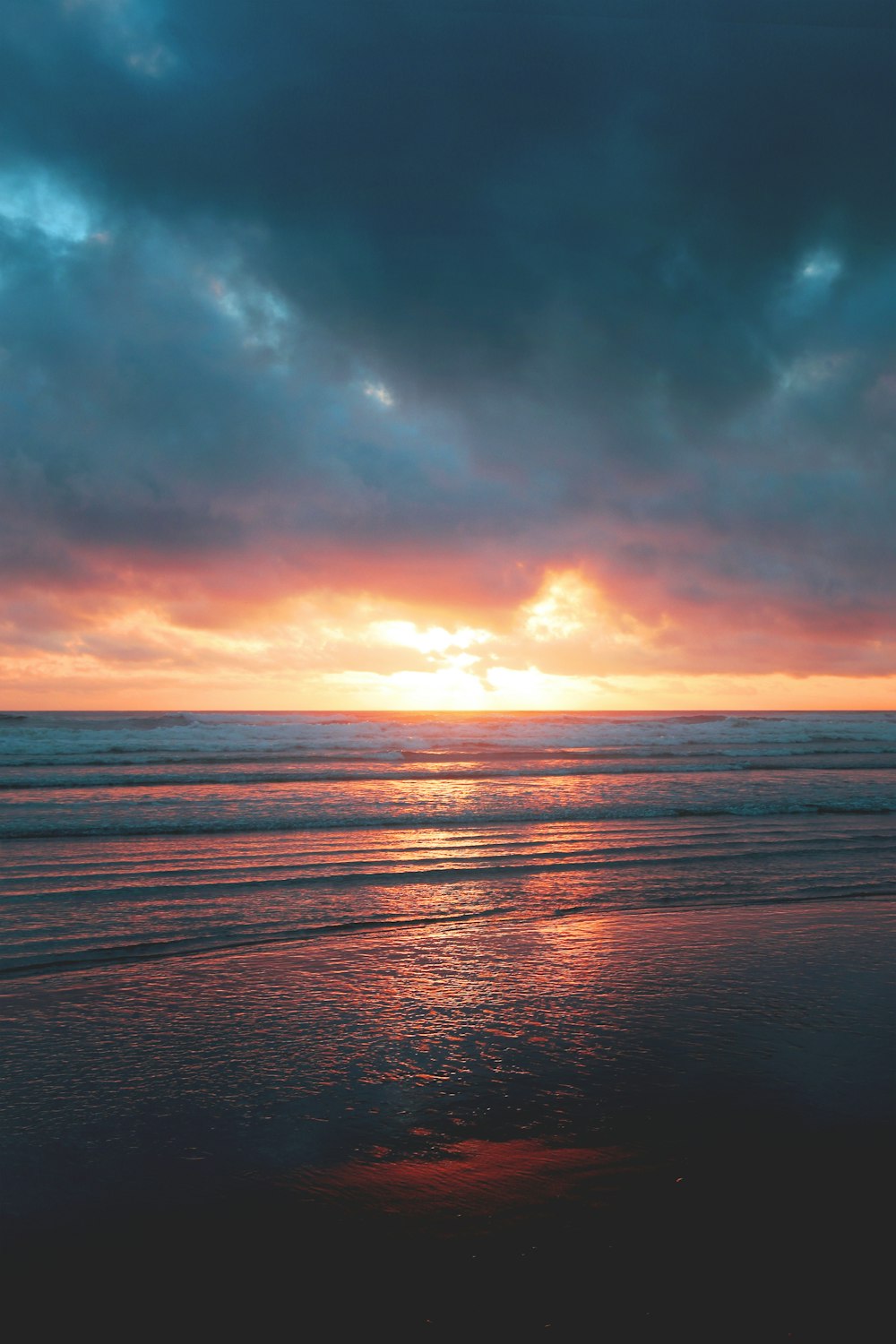 blue sea under a dramatic sky during golden hour