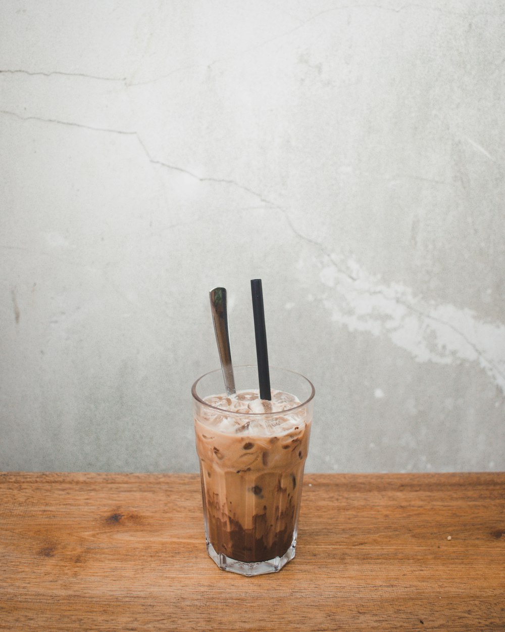 clear crystal glass with beverage and plastic sipping straw