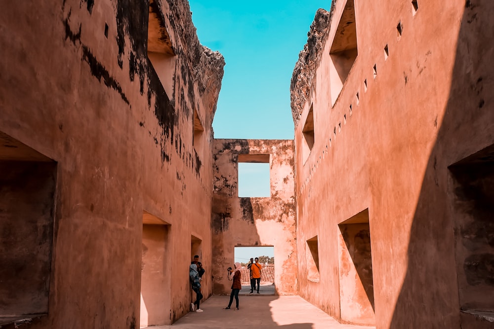 people standing in alleyway between houses during daytime