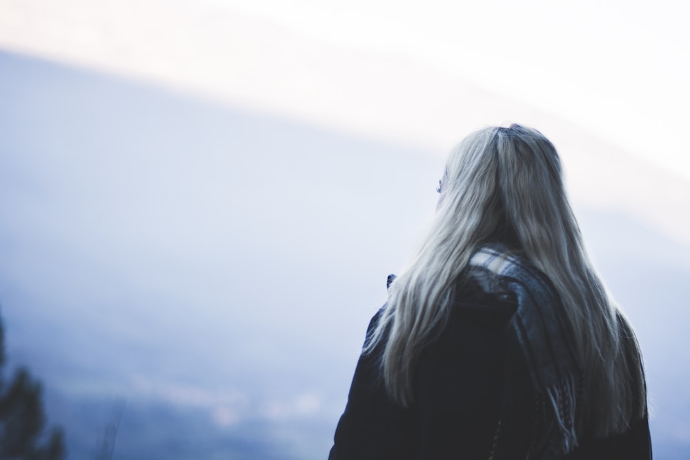 shallow focus photography of woman facing on mountain