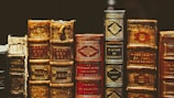 seven hardbound books on black surface