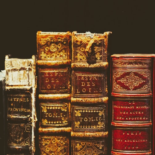 seven hardbound books on black surface