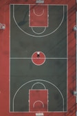 person lying in the middle of basketball court