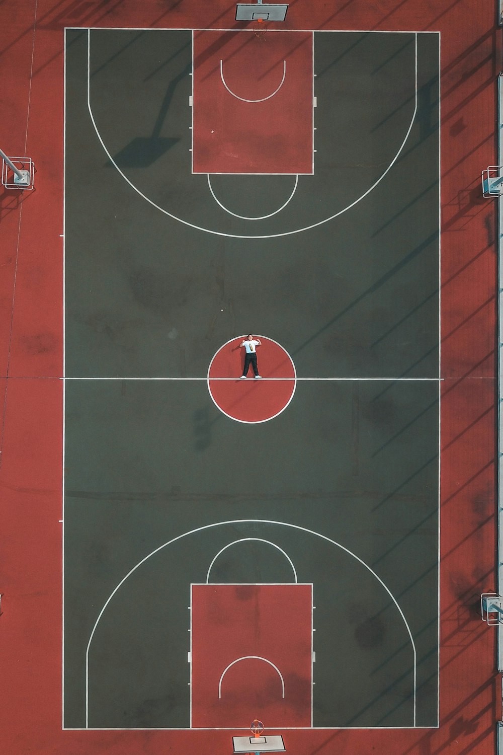 personne allongée au milieu d’un terrain de basket-ball