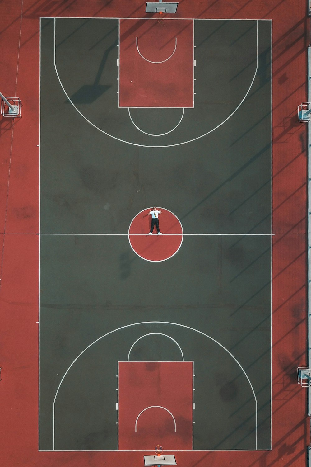 person lying in the middle of basketball court