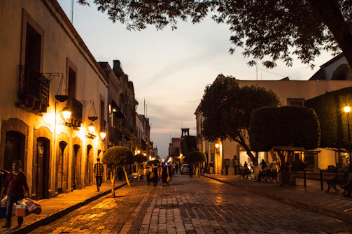 Historic cobblestone streets glowing warmly under vintage lanterns at dusk.