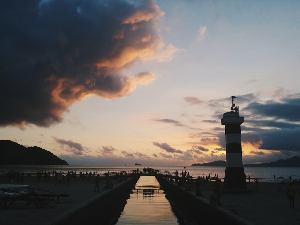 white and black lighthouse under cloudy sky