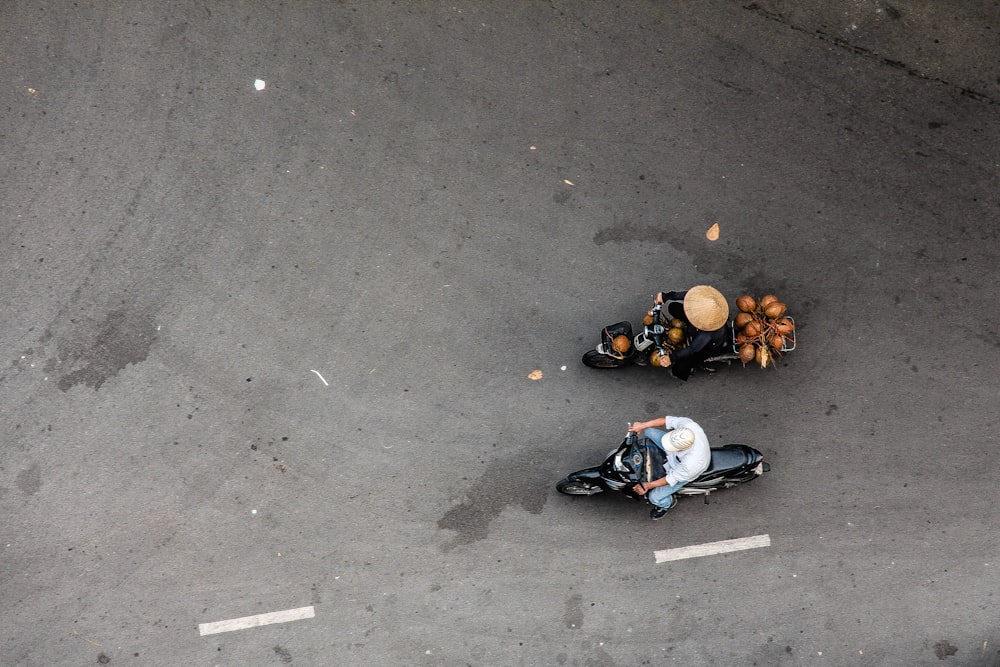 Zwei Personen fahren Motorrad auf Betonstraße
