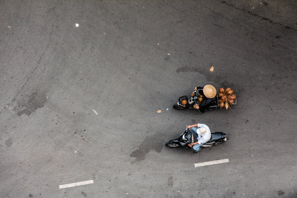 Due persone in sella a una motocicletta su una strada di cemento