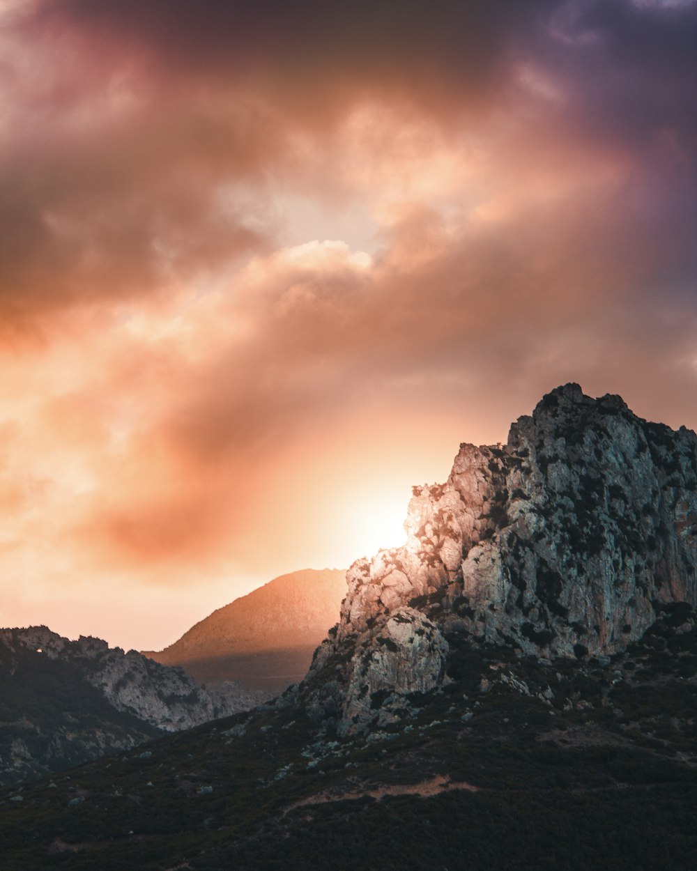 black and gray hill under cloudy sky during sunset