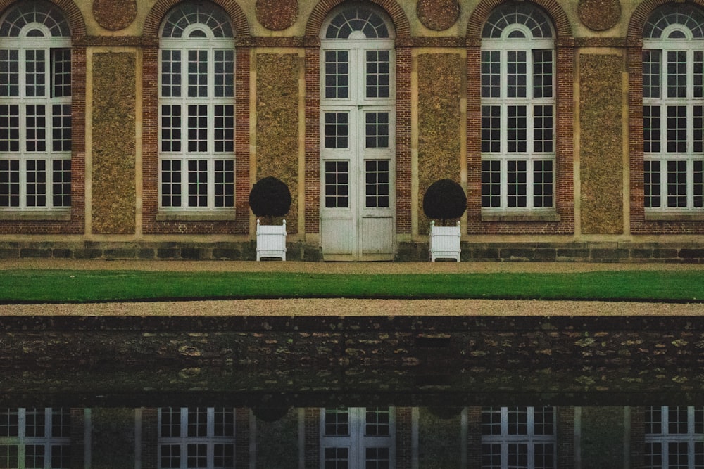 photograph of brown concrete structure with glass windows near body of water