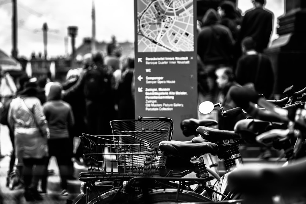 grayscale photography of bikes near walking people