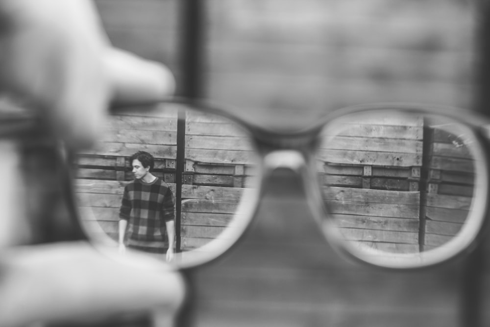 grayscale photo of man using by glasses