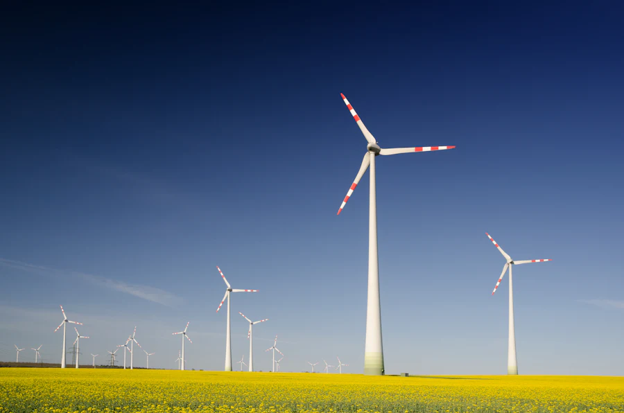 Onshore wind turbines standing across an open green field in daylight