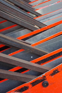 Close-up of rugged steel beams marked with safety orange paint, symbolizing durability.