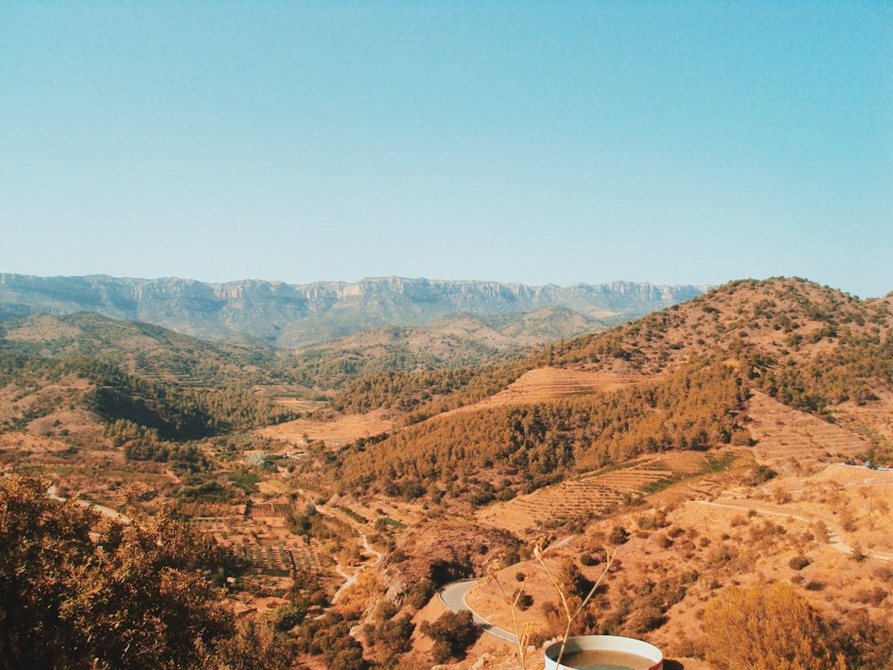 brown mountains with trees under blue clear sky during daytime