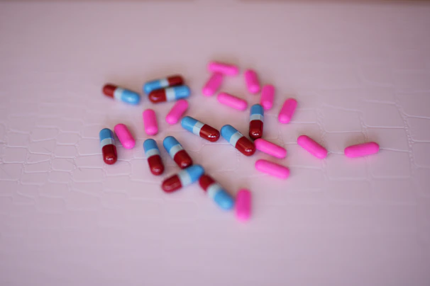 Close-up of the three color-coded pills—blue, pink, and obsidian—arranged neatly on a sleek white surface.
