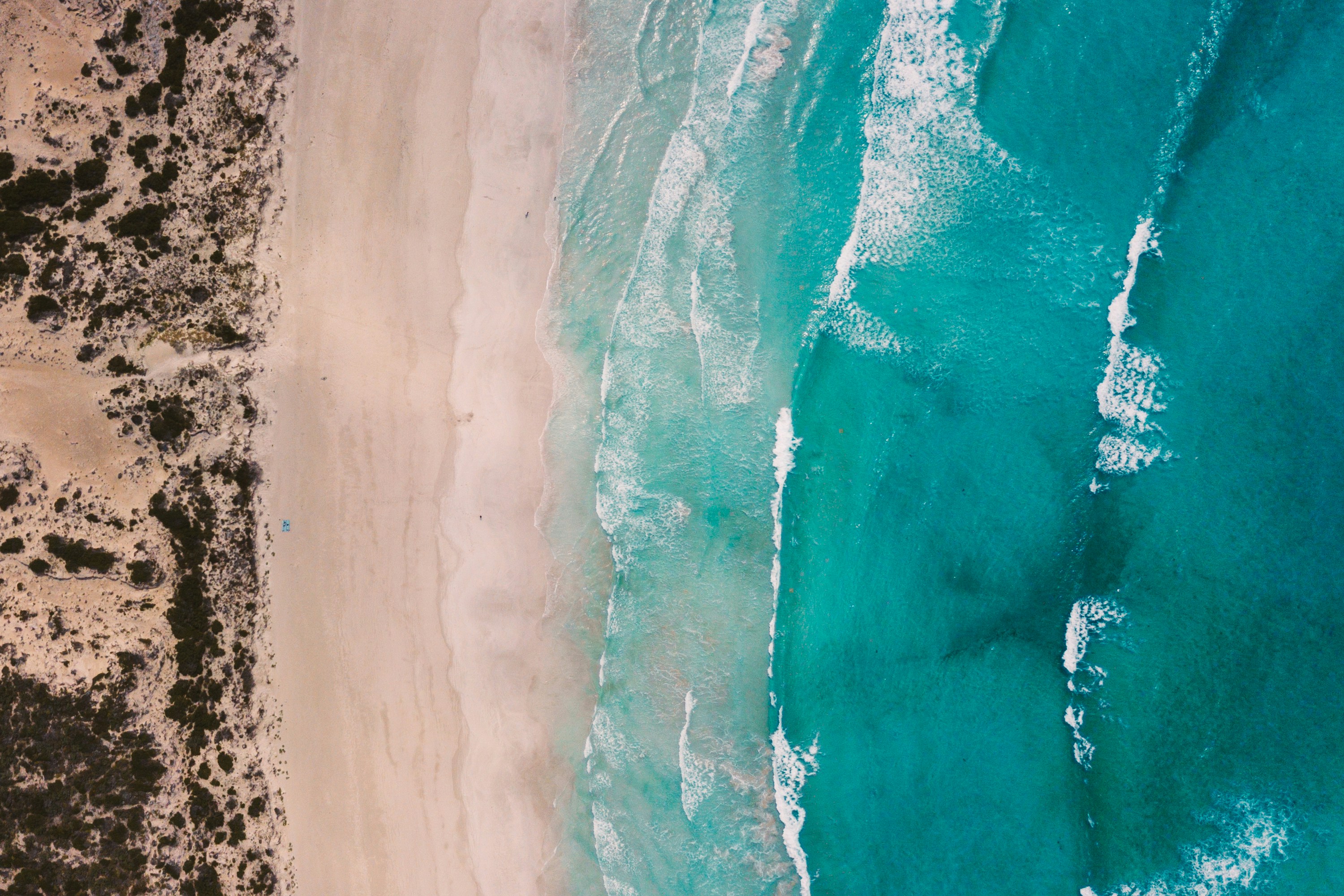 an aerial view of a sandy beach and ocean