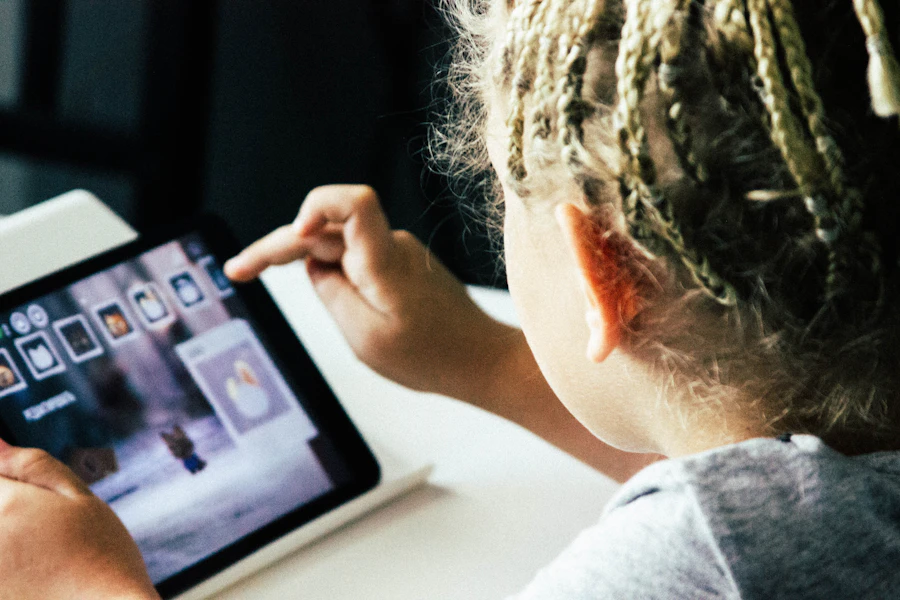 A child fully absorbed in a tablet screen