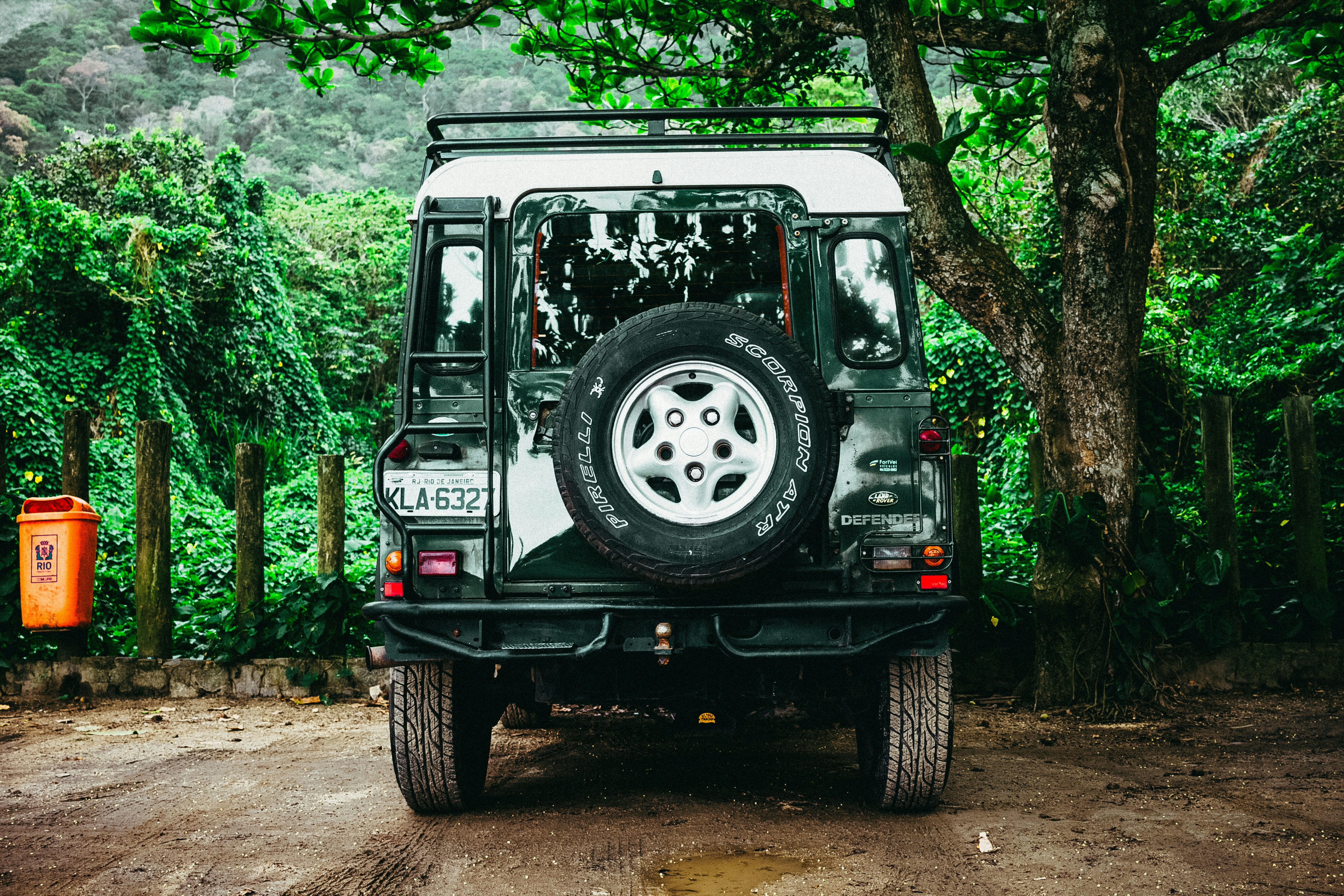 4WD vehicle parked on a mountain road surrounded by tropical rainforest in Dominica