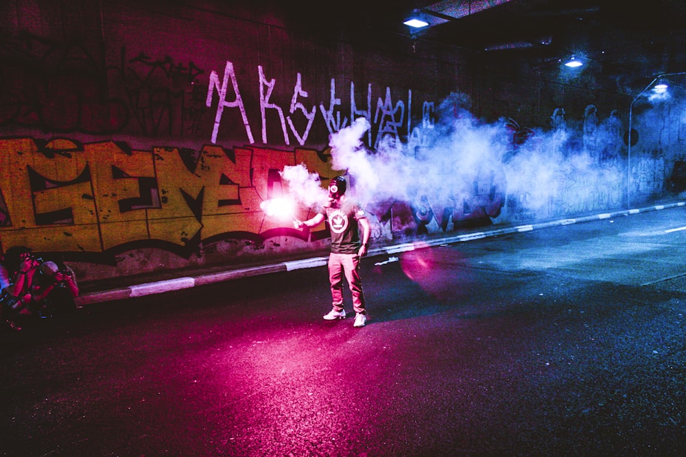 person standing holding flare in road