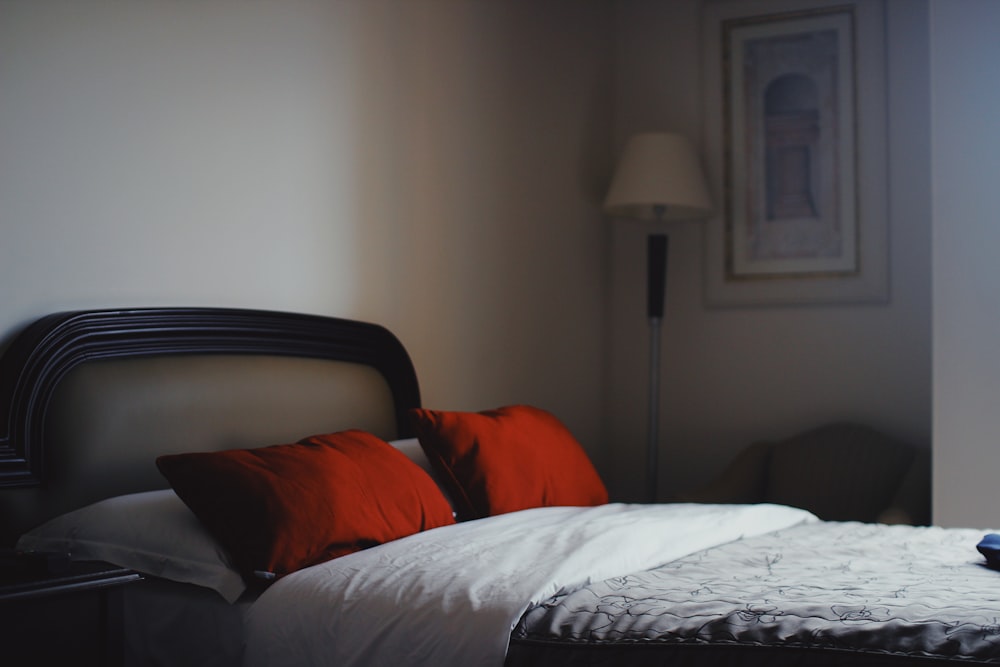 two red pillows and gray and white floral bedspread