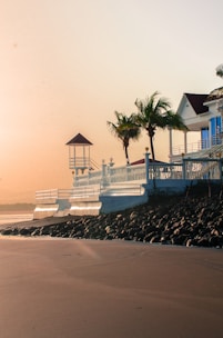 Cozy beachside bungalow nestled among palm trees in Goa at sunset