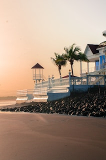 Cozy beachside bungalow nestled among palm trees in Goa at sunset