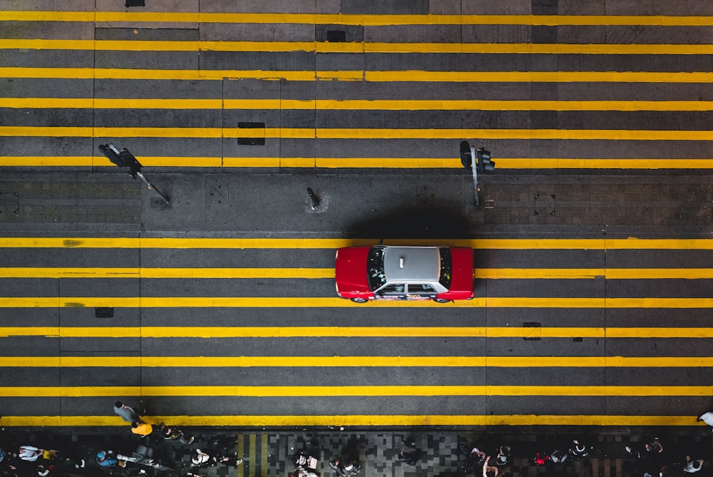 Photographie aérienne d’une voiture grise et rouge dans la rue