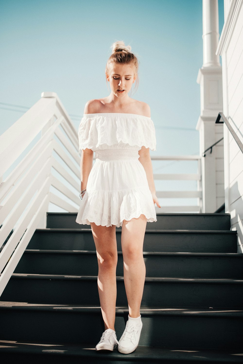 woman walking down stair under clear blue sky during daytime