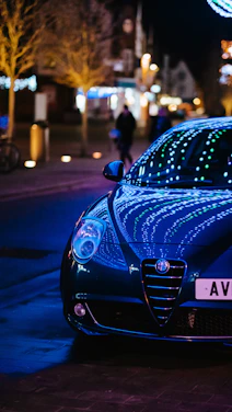 A sleek black car parked under city lights, reflecting the modern vibe of Drivevanta.