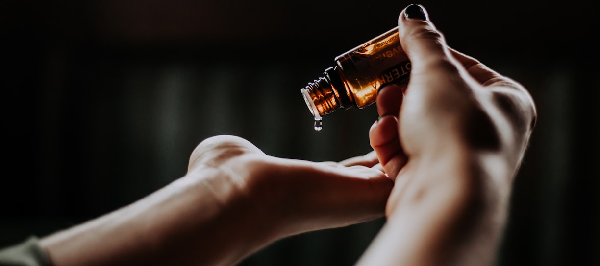 person holding amber glass bottle