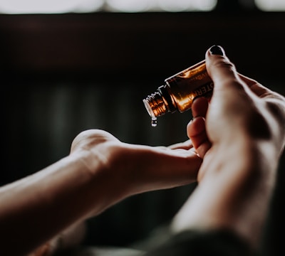 person holding amber glass bottle