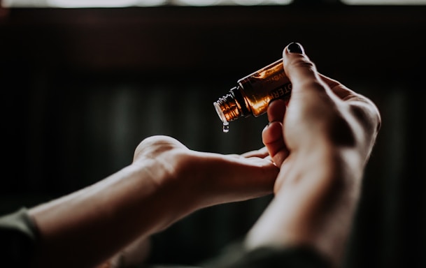 person holding amber glass bottle