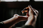 person holding amber glass bottle