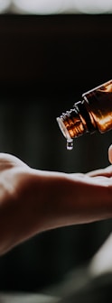 person holding amber glass bottle