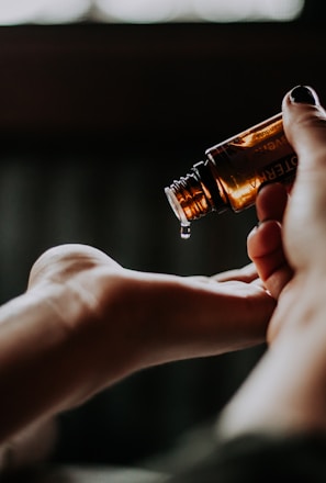 person holding amber glass bottle