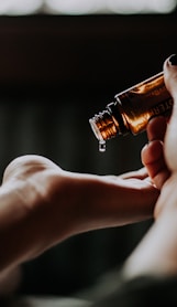 person holding amber glass bottle