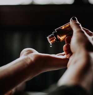 person holding amber glass bottle