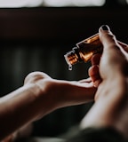 person holding amber glass bottle