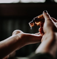 person holding amber glass bottle