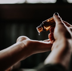 person holding amber glass bottle