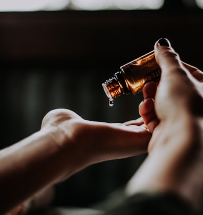 person holding amber glass bottle