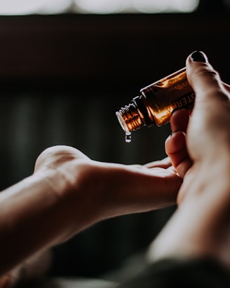 person holding amber glass bottle