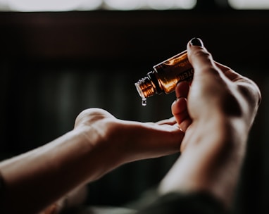 person holding amber glass bottle